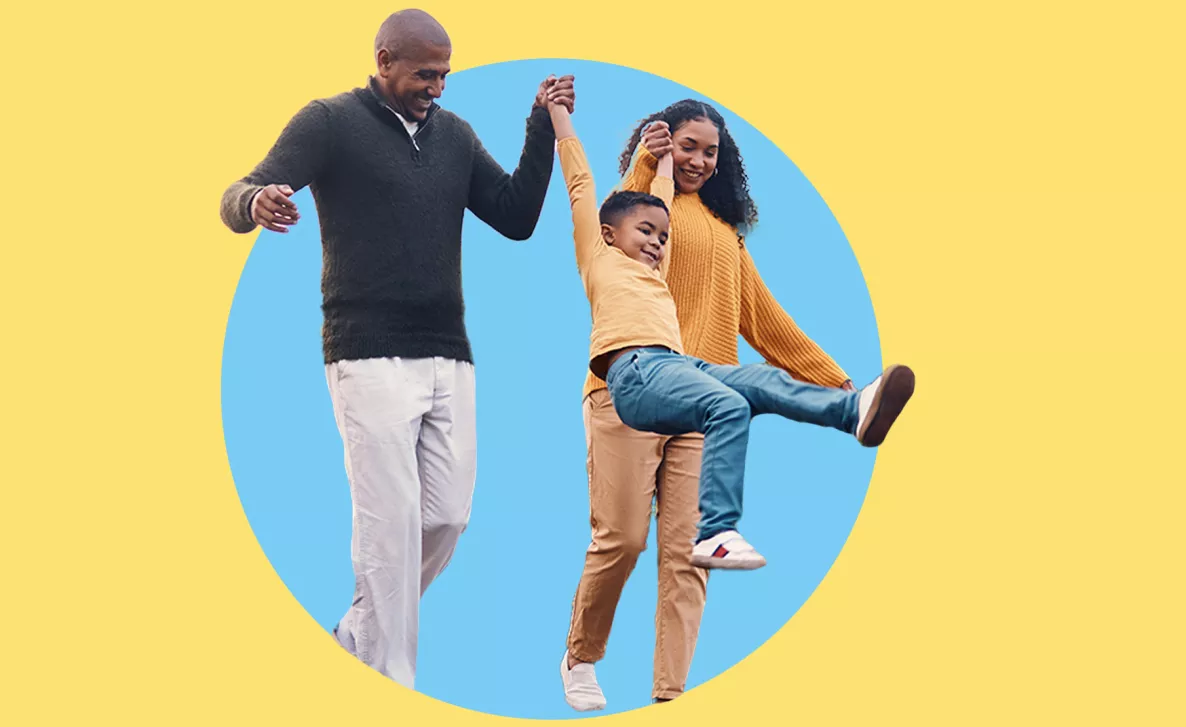  Young couple walking and swinging their young child in the air
